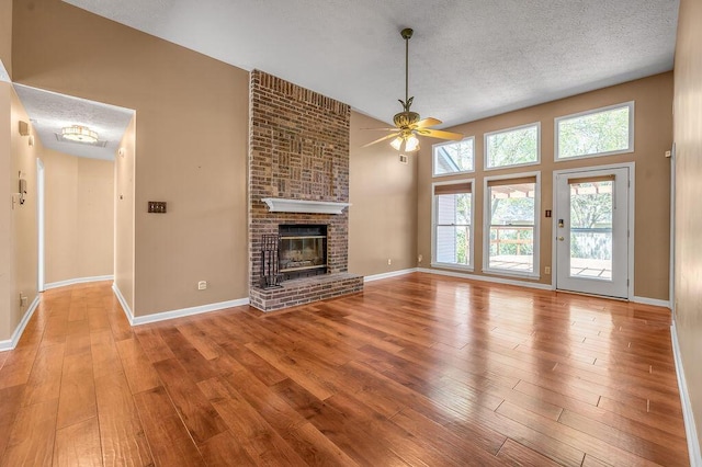 unfurnished living room featuring hardwood / wood-style flooring, ceiling fan, and plenty of natural light