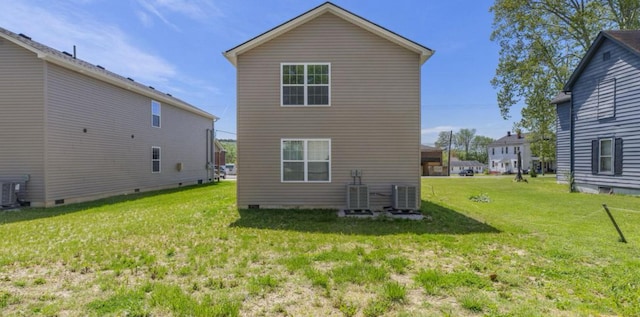 rear view of property featuring a lawn, central air condition unit, and crawl space