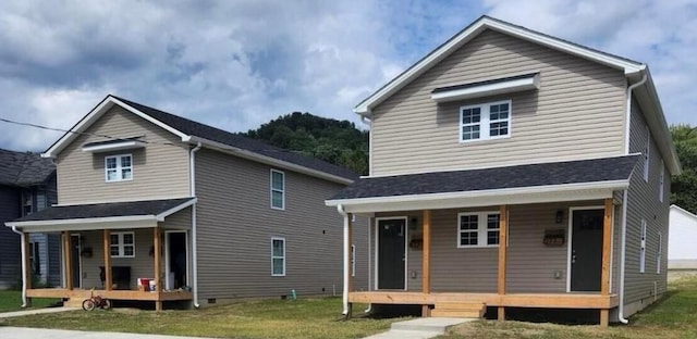 rear view of property with a lawn, crawl space, and covered porch