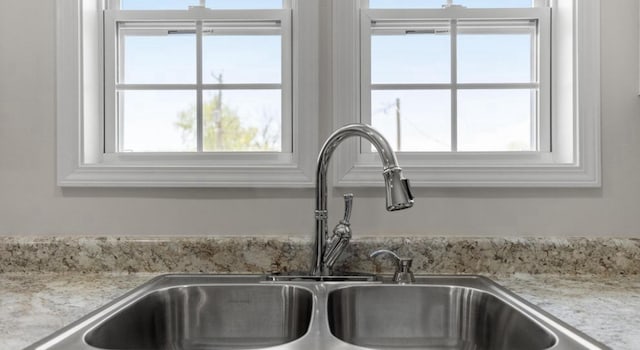 details with light stone countertops and a sink