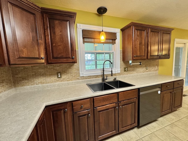 kitchen featuring a sink, decorative backsplash, light tile patterned flooring, light countertops, and dishwasher