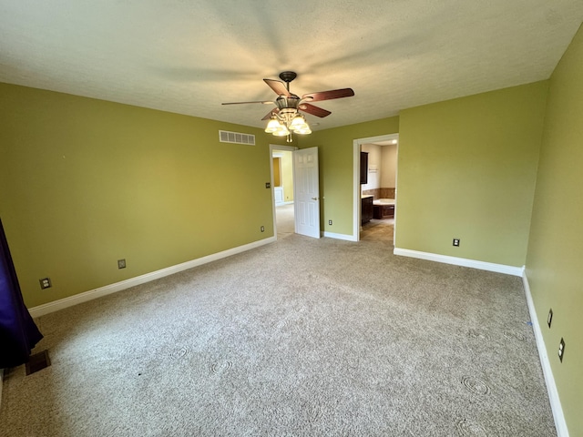 unfurnished bedroom with ensuite bath, visible vents, carpet flooring, and baseboards