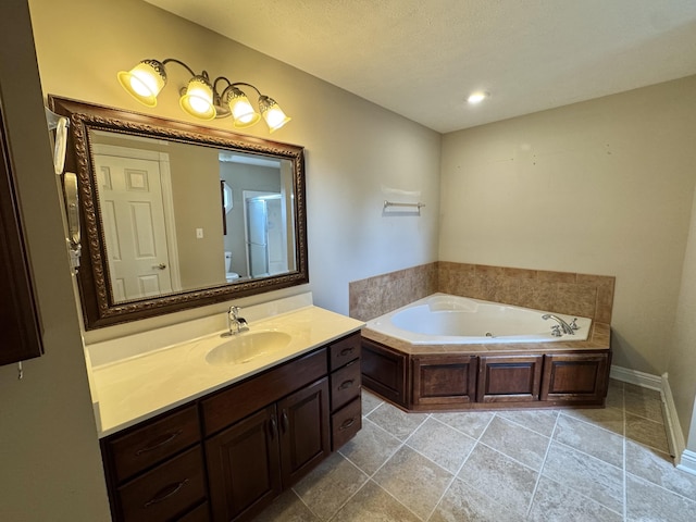 bathroom featuring recessed lighting, vanity, toilet, baseboards, and a garden tub