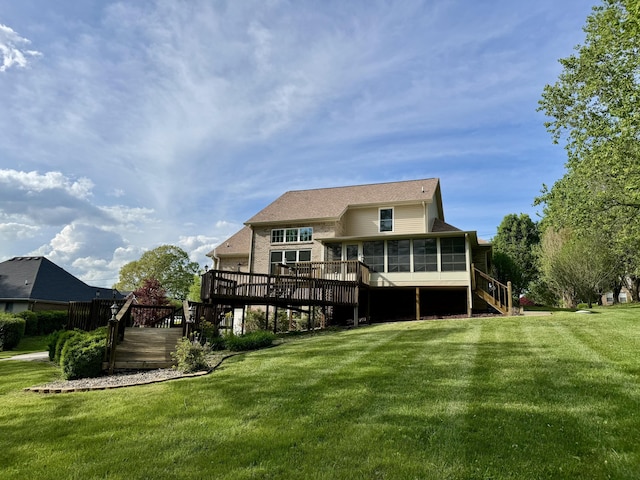 rear view of house featuring a sunroom, a deck, a yard, and stairway