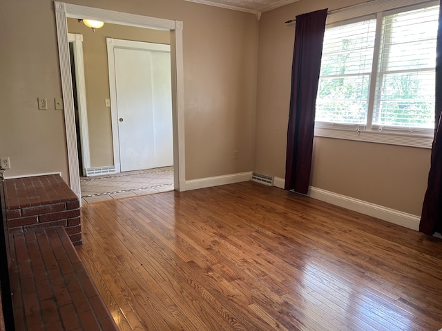 513 Sharp Gap Rd, Barbourville, KY 40906 - spare room featuring wood-type flooring, crown molding, visible vents, and baseboards