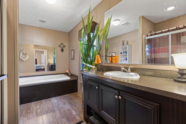 12739 Stulltown Rd, Hope, KY 40334 - full bath featuring wood finished floors, ensuite bathroom, vanity, a stall shower, and a textured ceiling