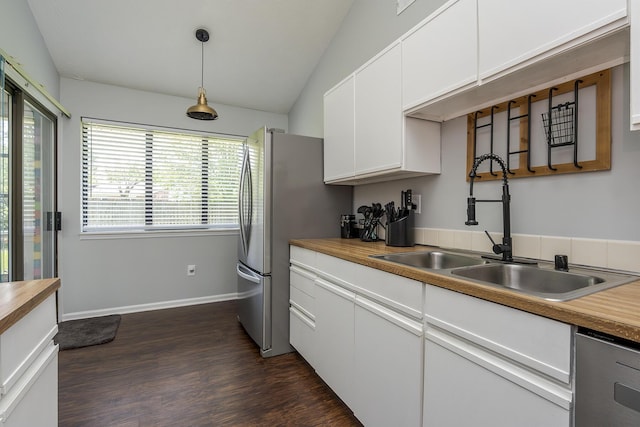 kitchen with dark wood finished floors, butcher block countertops, stainless steel appliances, a sink, and white cabinetry