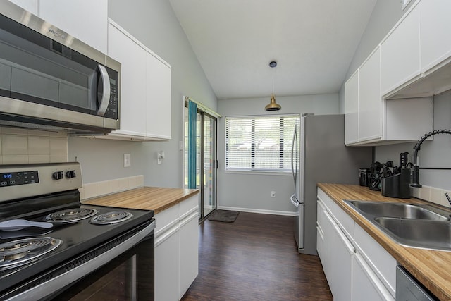 kitchen with lofted ceiling, white cabinetry, appliances with stainless steel finishes, butcher block countertops, and dark wood-type flooring
