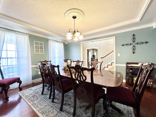 dining room featuring a textured ceiling, crown molding, and a tray ceiling