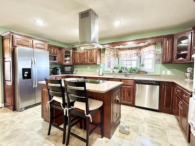 kitchen featuring a center island, a textured ceiling, island range hood, and stainless steel appliances