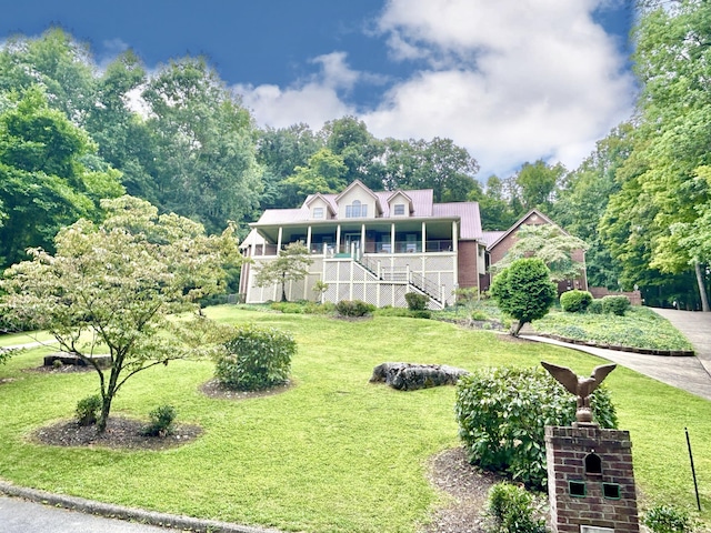 view of front of home featuring a front yard, stairway, and covered porch