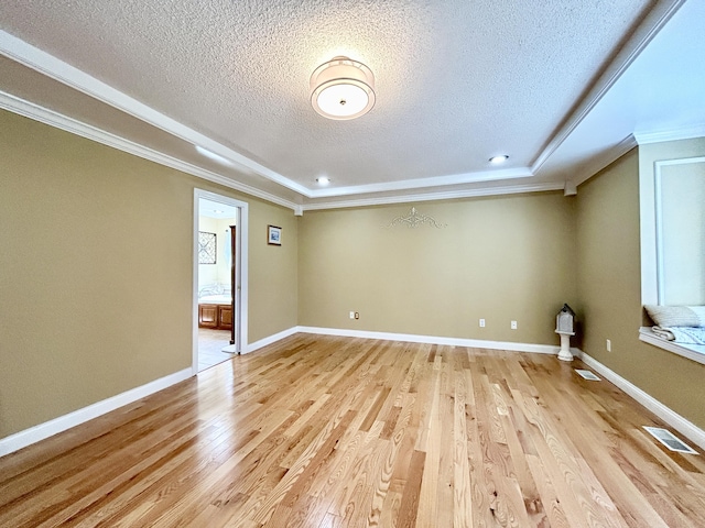 unfurnished room featuring a textured ceiling, visible vents, crown molding, and light wood-style flooring