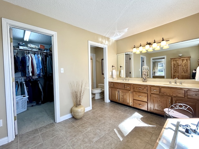 bathroom featuring a textured ceiling, a sink, and tile patterned floors