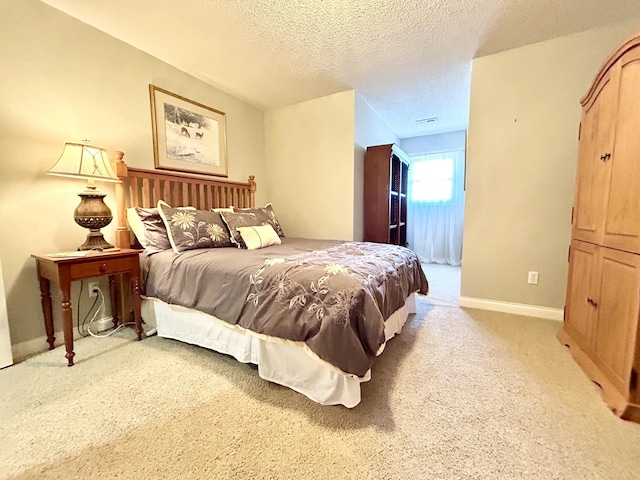 bedroom featuring a textured ceiling, visible vents, light carpet, and baseboards