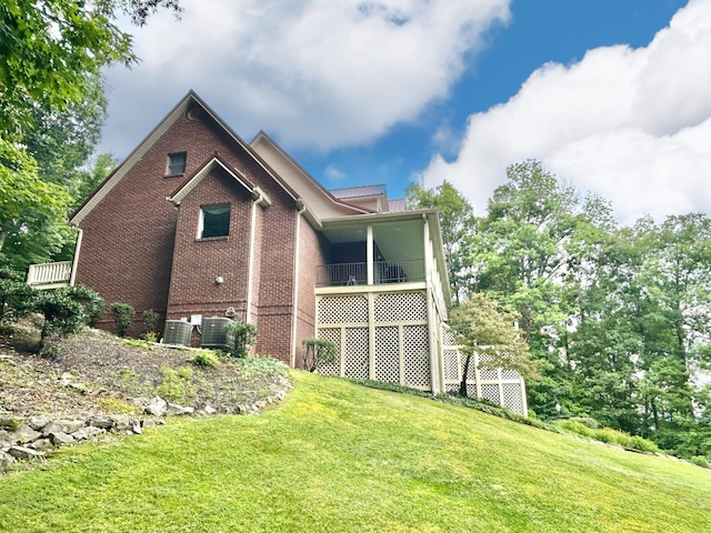 back of property with a lawn, central AC, and brick siding