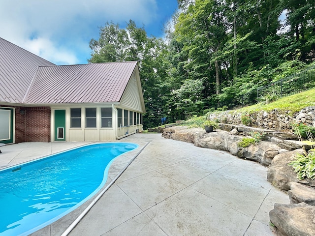 pool with a patio and fence