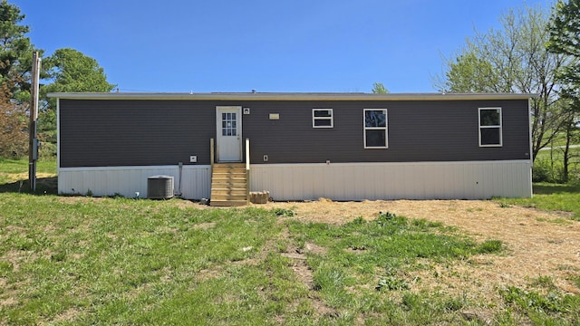 back of house with a lawn, central air condition unit, and entry steps