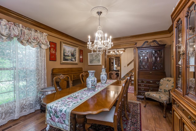 dining space featuring visible vents, stairs, wood finished floors, and a notable chandelier