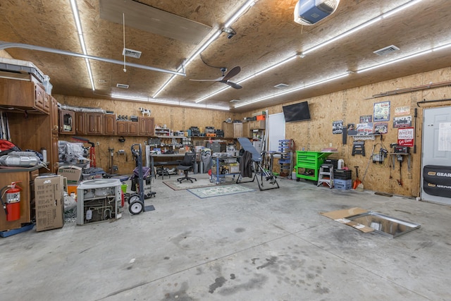 garage with visible vents, a garage door opener, and a workshop area