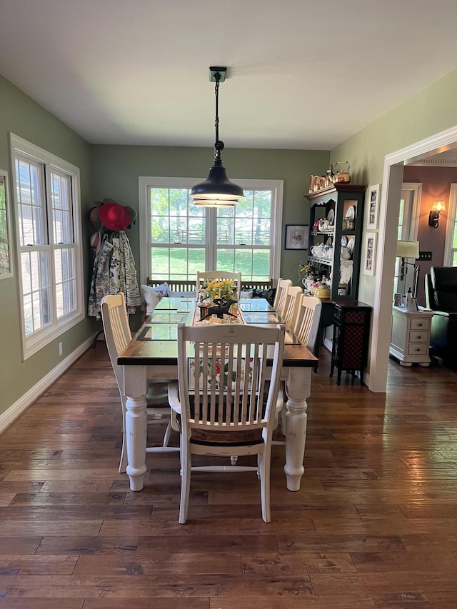 dining space featuring dark wood-style flooring, baseboards, and a healthy amount of sunlight