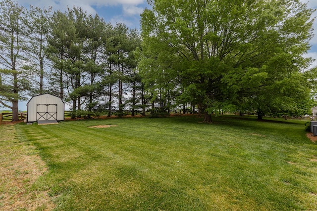 view of yard with a barn, fence, and an outdoor structure