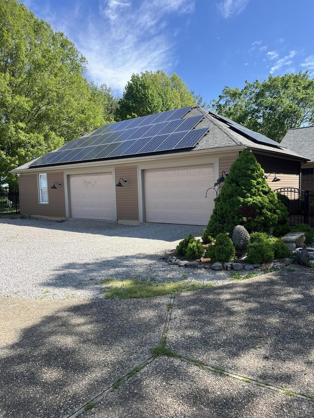 detached garage with fence and solar panels