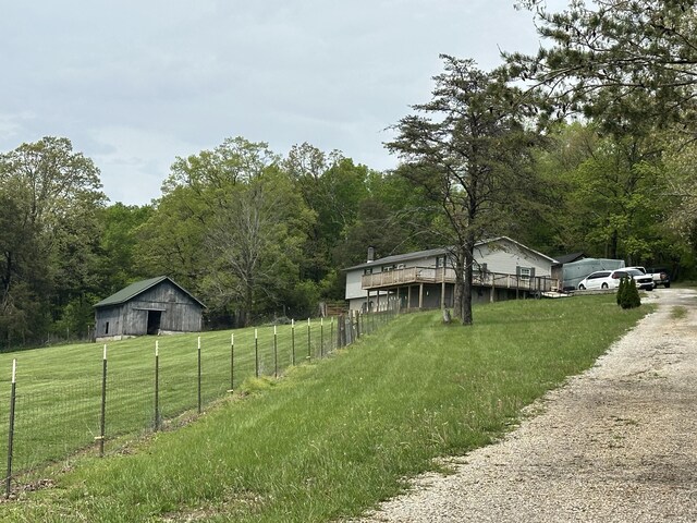 91 Barnett Rd, Brodhead, KY 40409 - view of yard featuring fence, dirt driveway, an outbuilding, and a forest view