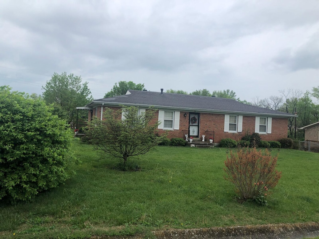 single story home with a front lawn and brick siding