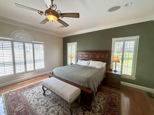 bedroom with crown molding, visible vents, baseboards, multiple windows, and wood finished floors