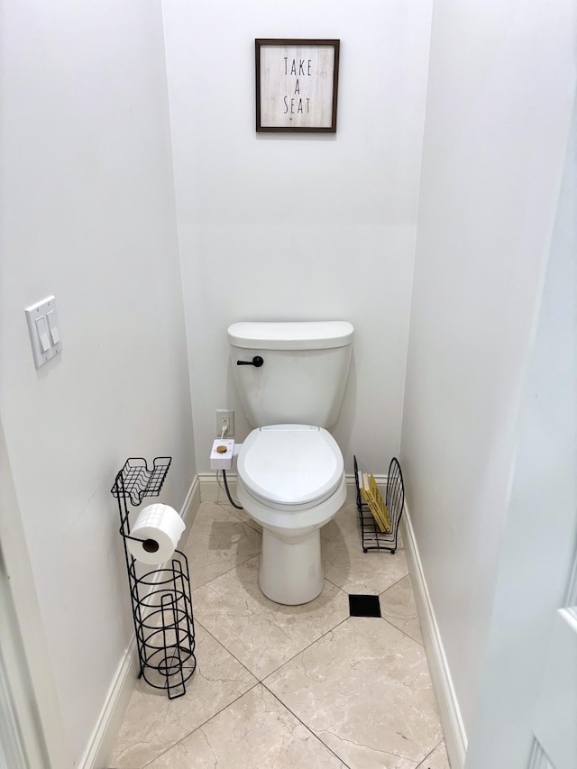 bathroom with toilet and baseboards