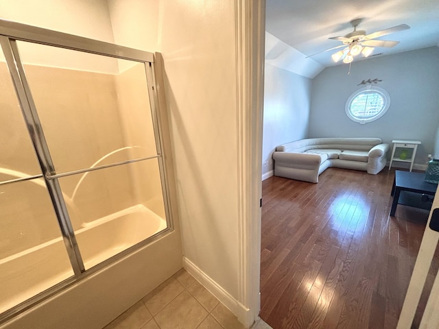 bathroom featuring baseboards, hardwood / wood-style flooring, ceiling fan, and lofted ceiling