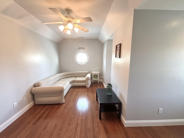 living area featuring a ceiling fan, vaulted ceiling, wood finished floors, and baseboards