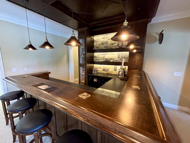 bar with ornamental molding, hanging light fixtures, indoor wet bar, and baseboards