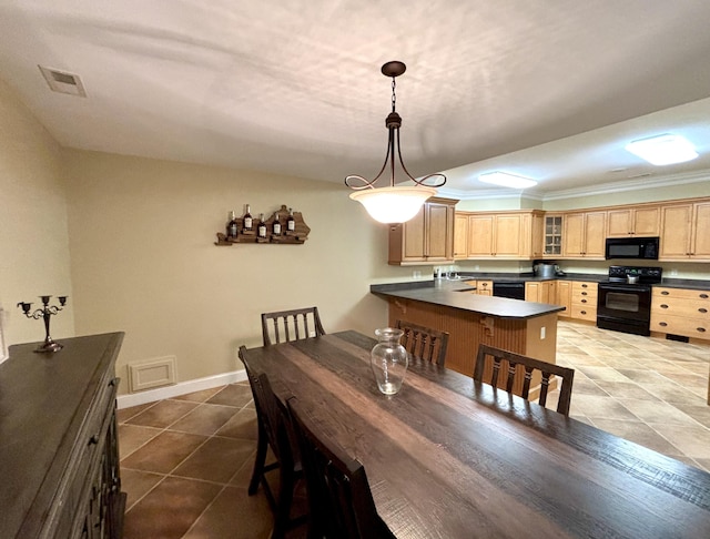 tiled dining room featuring baseboards, visible vents, ornamental molding, and a sink