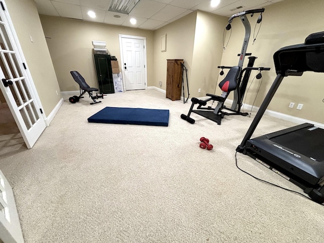workout room with a paneled ceiling, carpet, and baseboards