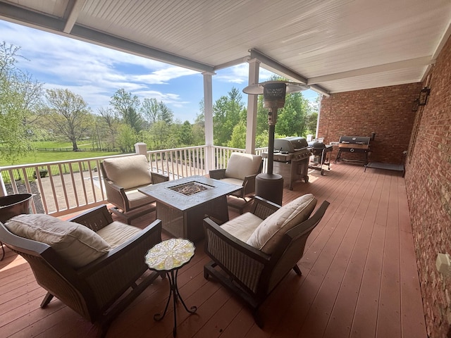 wooden deck featuring an outdoor living space with a fire pit and a grill