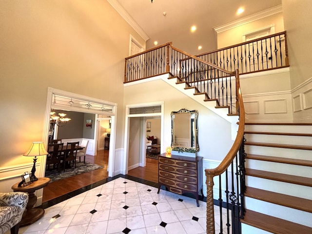 stairway featuring crown molding, baseboards, recessed lighting, tile patterned flooring, and a high ceiling