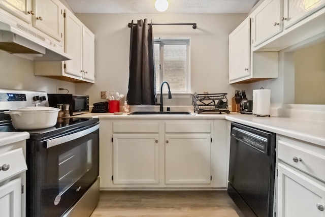 kitchen featuring a sink, under cabinet range hood, black dishwasher, electric range oven, and white cabinets