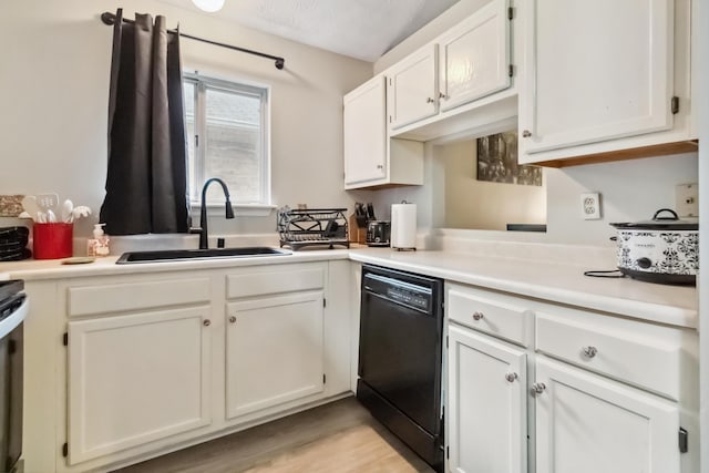 kitchen with black dishwasher, a sink, white cabinetry, and light countertops