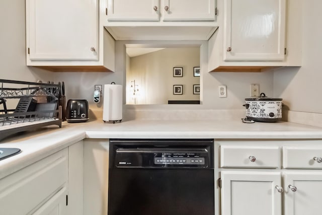 kitchen with white cabinetry, black dishwasher, and light countertops