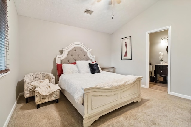 bedroom featuring connected bathroom, light colored carpet, vaulted ceiling, baseboards, and visible vents