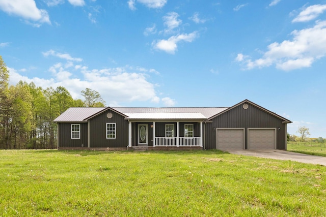 ranch-style house featuring a front yard, a garage, metal roof, covered porch, and driveway
