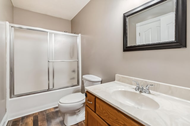 full bathroom with enclosed tub / shower combo, wood finished floors, toilet, and vanity