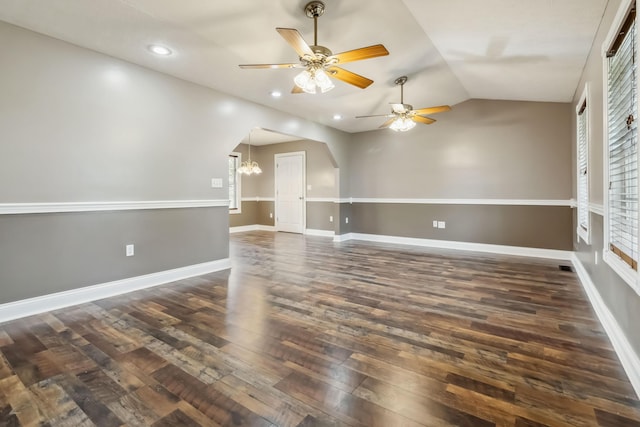 spare room featuring recessed lighting, arched walkways, vaulted ceiling, ceiling fan with notable chandelier, and dark wood-style flooring