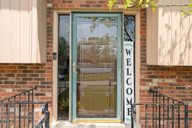 doorway to property featuring brick siding