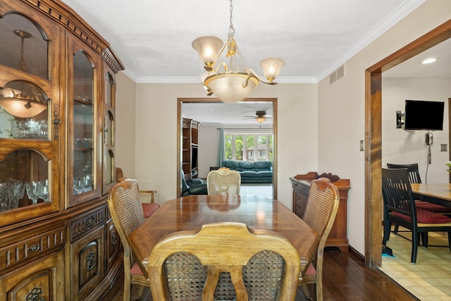 dining space featuring crown molding, dark wood-style flooring, a chandelier, and visible vents