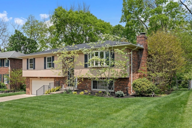 raised ranch with a garage, a front yard, a chimney, brick siding, and concrete driveway
