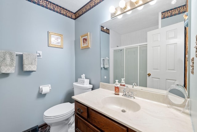 bathroom with vanity, a stall shower, and toilet