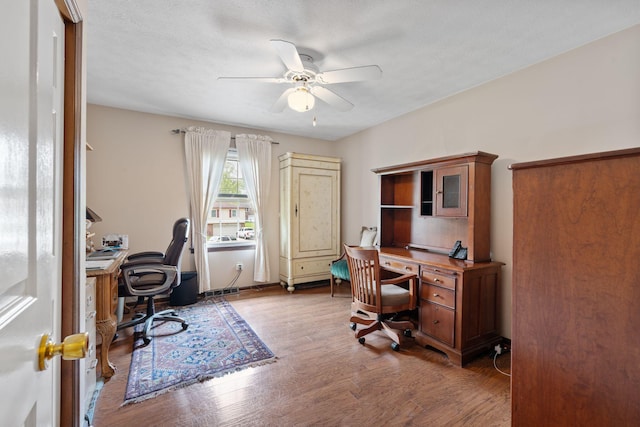 office with a ceiling fan and wood finished floors