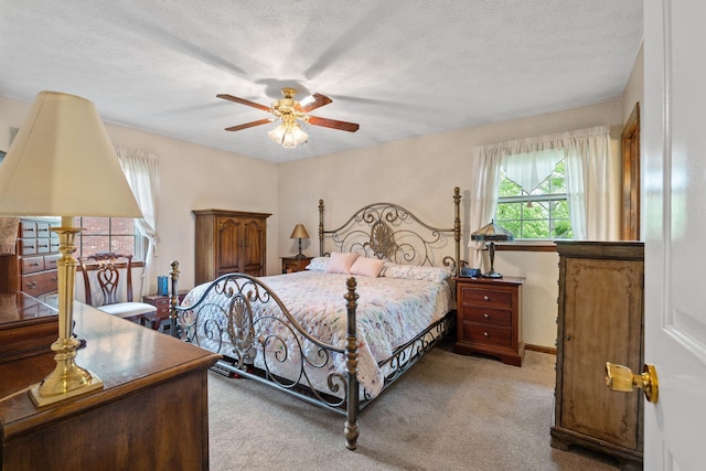 carpeted bedroom with a ceiling fan, baseboards, and a textured ceiling